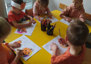 Na zdjęciu widać dzieci które wykonują pracę plastyczną dynie.