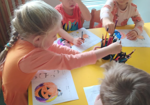 Na zdjęciu widać dzieci które wykonują pracę plastyczną dynie.