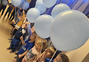 Na zdjęciu widać dzieci które trzymają balony niebieskie z okazji Międzynarodowy Dzień Praw Dziecka.