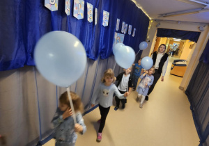 Na zdjęciu widać dzieci które trzymają balony niebieskie z okazji Międzynarodowy Dzień Praw Dziecka.