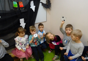 Na zdjęciu widać dzieci z karteczkami andrzejkowymi.