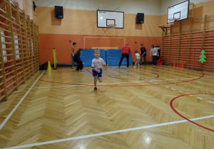 Na zdjęciu widać dziecko które biegnie podczas zawodów sportowych.