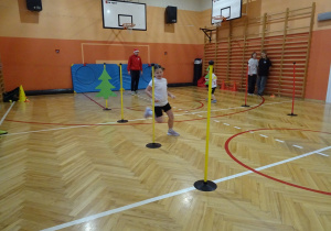 Na zdjęciu widać dziecko które biegnie podczas zawodów sportowych.