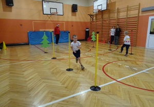 Na zdjęciu widać dziecko które biegnie podczas zawodów sportowych.