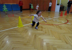 Na zdjęciu widać dziecko które biegnie podczas zawodów sportowych.
