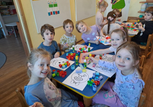 Na zdjęciu widać dzieci które wykonują pracę plastyczną wesoły klaun.