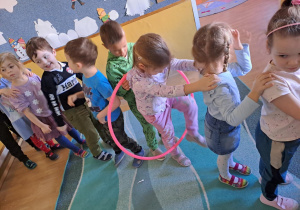 Na zdjęciu widać dzieci które ćwiczą z hula-hop.