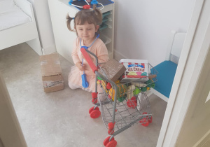 Na zdjęciu widać dziewczynkę która bawi się w sklep.