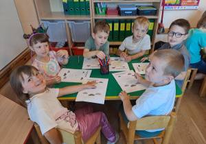 Na zdjęciu widać dzieci które wykonują zadania w kartach pracy.
