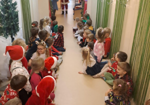 Na zdjęciu widać dzieci i Św Mikołaja który wręcza prezenty.