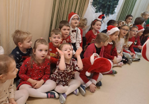 Na zdjęciu widać dzieci i Św Mikołaja który wręcza prezenty.