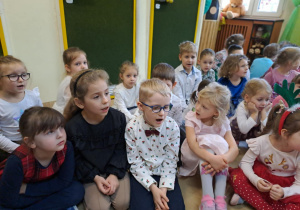 Na zdjęciu widać dzieci przy wspólnym kolędowaniu.