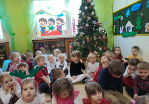 Na zdjęciu widać dzieci przy wspólnym kolędowaniu.