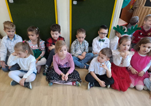 Na zdjęciu widać dzieci przy wspólnym kolędowaniu.