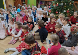 Na zdjęciu widać dzieci przy wspólnym kolędowaniu.