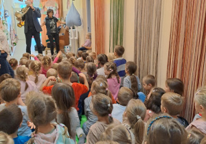 Na zdjęciu widać dzieci które zapoznają się z instrumentem róg.
