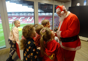 Na zdjęciu widać Mikołaja oraz dzieci na stadionie Widzewa.