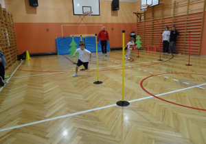 Na zdjęciu widać dziecko które biegnie podczas zawodów sportowych.