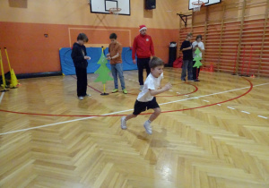 Na zdjęciu widać dziecko które biegnie podczas zawodów sportowych.