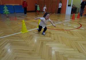 Na zdjęciu widać dziecko które biegnie podczas zawodów sportowych.