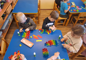 Na zdjęciu widać dzieci które wykonują pracę plastyczną wesoły klaun.