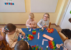 Na zdjęciu widać dzieci które wykonują pracę plastyczną wesoły klaun.