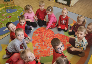 Na zdjęciu widać dzieci które pokazują serce z okazji walentynek przez siebie wykonane.