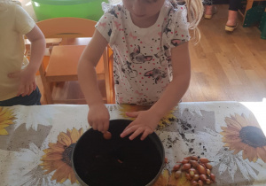 Na zdjęciu widać dziecko które sadzi kwiaty.