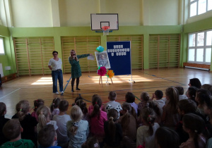 Na zdjęciu widać dzieci na scenie które recytują wiersz.