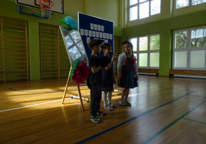 Na zdjęciu widać dzieci na scenie które recytują wiersz.