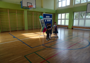 Na zdjęciu widać dzieci na scenie które recytują wiersz.