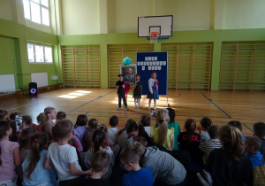 Na zdjęciu widać dzieci na scenie które recytują wiersz.