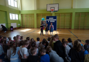 Na zdjęciu widać dzieci na scenie które recytują wiersz.