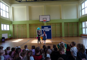 Na zdjęciu widać dzieci na scenie które recytują wiersz.