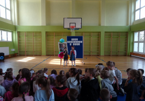 Na zdjęciu widać dzieci na scenie które recytują wiersz.