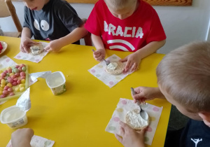 Na zdjęciu widać dzieci które układają kompozycję kwiatową na wafelkach według własnego pomysłu.