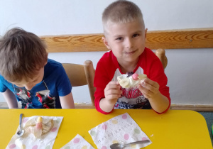 Na zdjęciu widać dziecko które układa kompozycję kwiatową na wafelkach według własnego pomysłu.