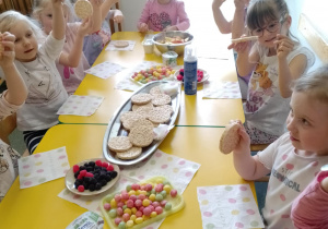 Na zdjęciu widać dziecko które układa kompozycję kwiatową na wafelkach według własnego pomysłu.