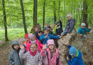 Na zdjęciu widać dzieci w lesie w Łagiewnikach dzieci poznają kwiaty.