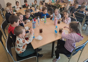 Na zdjęciu widać dzieci na stołówce w lesie dzieci jedzą śniadanie.