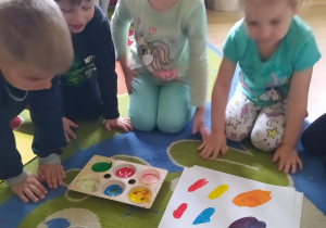 Na zdjęciu widać dzieci które malują farbami.