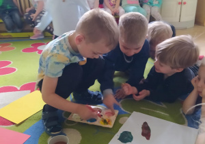 Na zdjęciu widać dzieci które malują farbami.