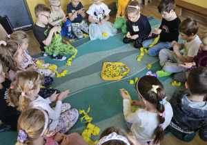 Na zdjęciu widać dzieci które wykonują pracę plastyczną z okazji dnia pszczół.