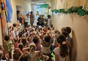 Na zdjęciu widać dzieci które oglądają koncert Pan gra na trąbce.