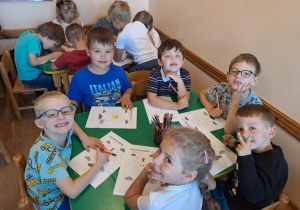 Na zdjęciu widać dzieci które wykonują zadania w kartach pracy.