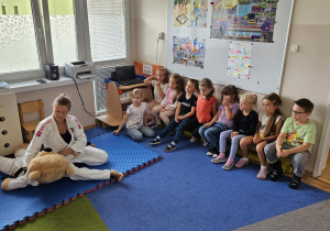 Na zdjęciu widać Panią która pokazuje dzieciom jak się bronić.