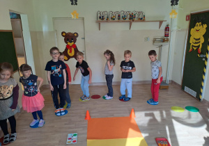 Na zdjęciu widać dzieci które wykonują podskoki na kropkach. Zabawy ruchowe.