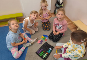 Na zdjęciu widać dzieci które bawią się klockami "numicon"