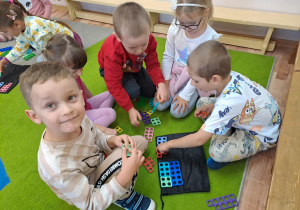 Na zdjęciu widać dzieci które bawią się klockami "numicon"