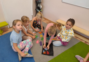 Na zdjęciu widać dzieci które bawią się klockami "numicon"